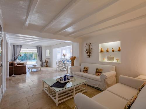 a living room with white furniture and a table at Holiday Home Villa Cyrnos by Interhome in Sainte-Maxime