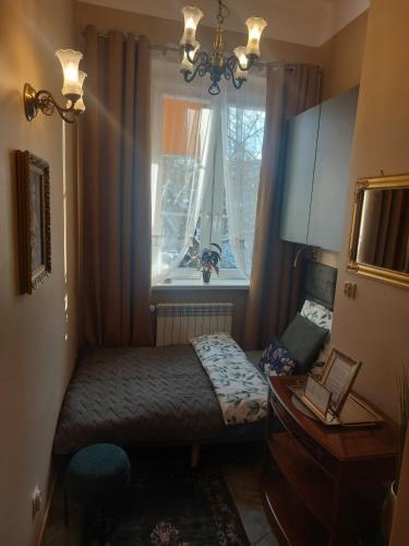 a small bedroom with a bed and a window at Apartament przy ratuszu in Zielona Góra