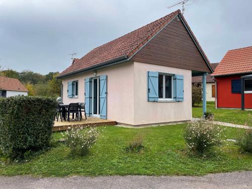 a house with a table and chairs in a yard at La maison de la plage in Giffaumont