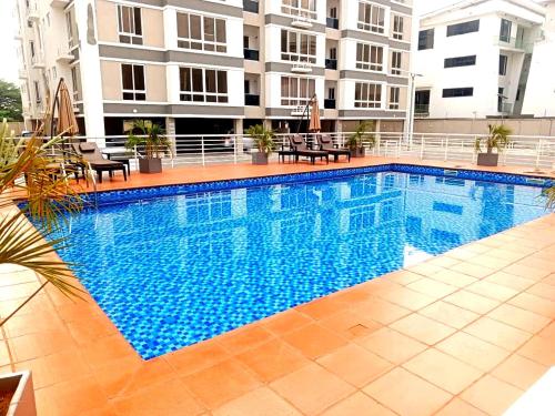 a large swimming pool in front of a building at Cozy Ikoyi Retreat in Lagos