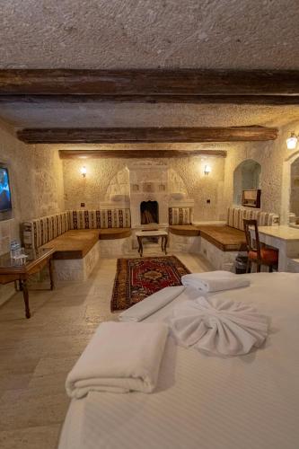 a large room with two beds and a fireplace at Kemerhan Cave Suites in Urgup