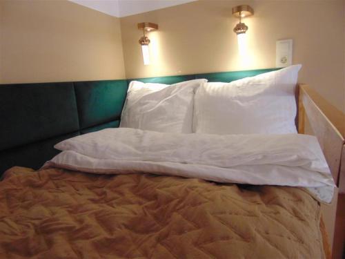 a bed with white sheets and pillows in a room at Apartament przy ratuszu in Zielona Góra