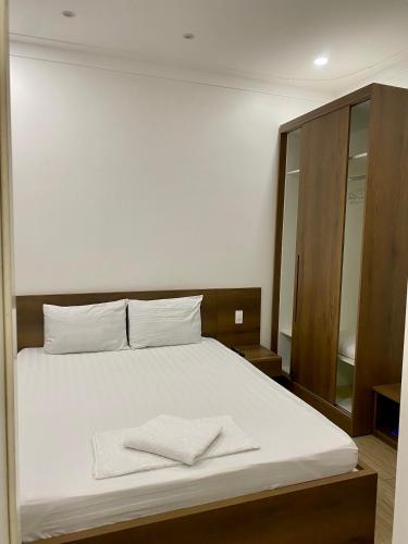 a bedroom with a white bed with two towels on it at Khách Sạn Hoa Phượng in Ho Chi Minh City