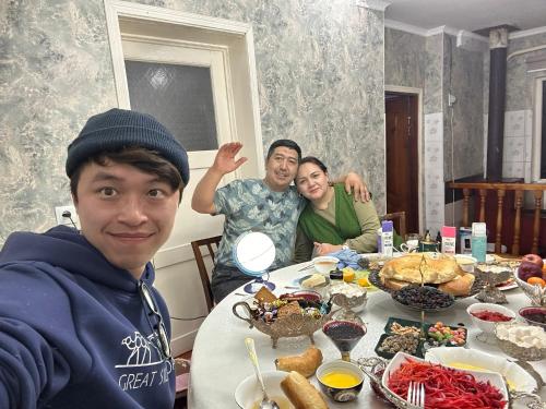 a group of people sitting at a table with food at GeshouseAselBarskoon in Barskoon
