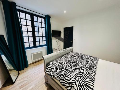 - une chambre avec un lit à motifs zébrés et une fenêtre dans l'établissement Le Gambetta - Proche du centre-ville et des thermes, à Rochefort