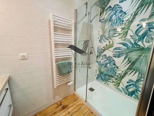 une douche avec une porte vitrée dans une salle de bain dans l'établissement Le Gambetta - Proche du centre-ville et des thermes, à Rochefort
