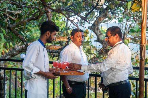 a group of men holding a tray of drinks at Trance rabara resort in Avissawella