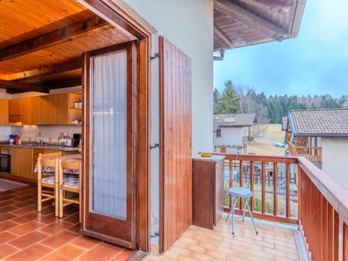 a balcony with a wooden door and a kitchen at Apartment Ermeti by Interhome in Sfruz