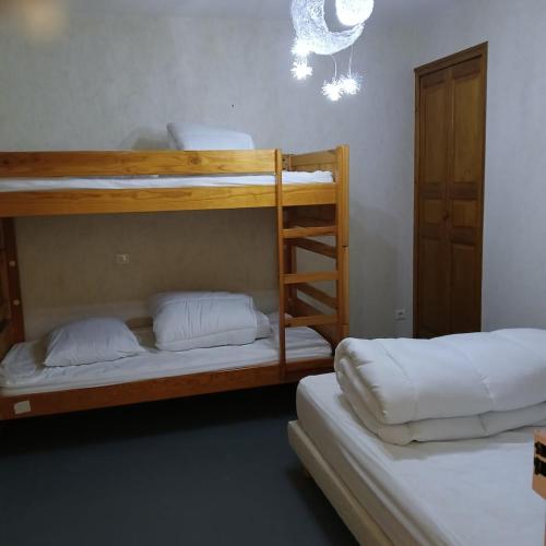 Cette chambre comprend 2 lits superposés avec des oreillers blancs. dans l'établissement joli T2, à La Bourboule
