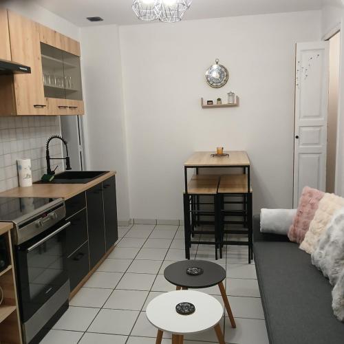 - une cuisine avec un canapé et une table dans une chambre dans l'établissement joli T2, à La Bourboule