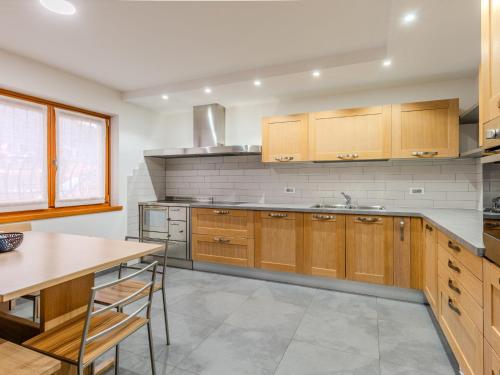 a large kitchen with wooden cabinets and a table at Apartment Elisa by Interhome in Ronzone