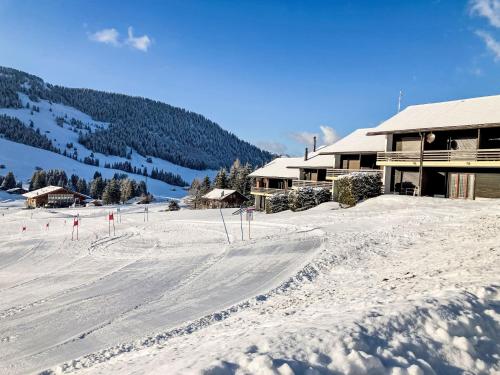 a snow covered ski slope in front of a lodge at Apartment Les Bluets by Interhome in Les Mosses
