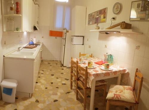 ヴェネツィアにあるApartment Minuettoのキッチン(シンク、テーブル、椅子付)