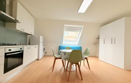 a kitchen with a table and chairs in a room at Ella vacanze in Grottammare