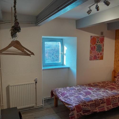 a bedroom with a bed and a window at Gîte NOCTUA chez Gîtes QUE CANTA in Saint-Julien-Vocance