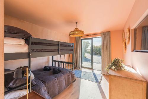 a bedroom with a bunk bed and a window at Du Cabana By Birch Stays in Rhosneigr