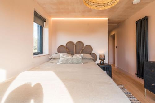 a bedroom with a large bed with a wooden headboard at Du Cabana By Birch Stays in Rhosneigr