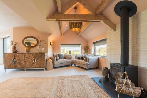a living room with a couch and a fireplace at Du Cabana By Birch Stays in Rhosneigr