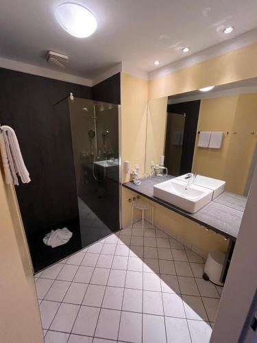 a bathroom with a sink and a shower at Parkhotel Green Garden in Bad Hersfeld