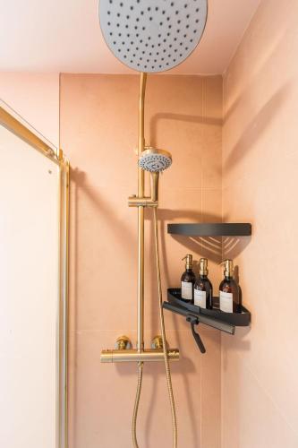 a bathroom with a shower with bottles on a shelf at Du Cabana By Birch Stays in Rhosneigr