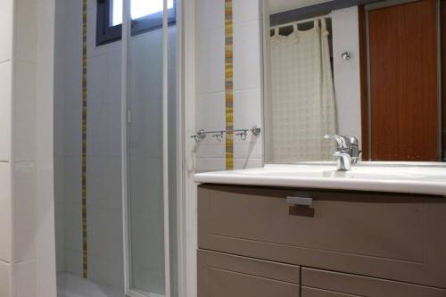 une salle de bain avec un lavabo et une douche avec un miroir dans l'établissement Maison 3 pièce 5 couchages Saint Pierre d'Oléron SPO000-003, à Saint-Pierre-dʼOléron