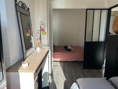 une petite chambre avec un lit et un miroir dans l'établissement Appartement cosy, à Chessy