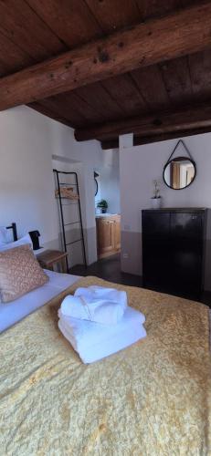 une chambre avec un lit avec des serviettes dessus dans l'établissement PROCHE UZES LE COCON DU PEINTRE ANGLAIS, à Sanilhac-et-Sagriès