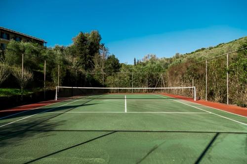 a tennis court with a net on top of it at Corfù Appartamenti Dellis - Close to the beach in Káto Spílaion