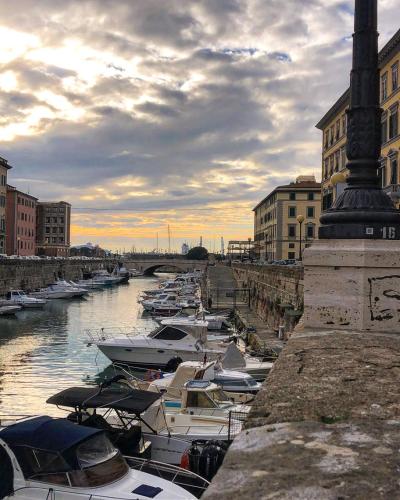 a group of boats are docked in a river at Cozy Stay in City Center in Livorno
