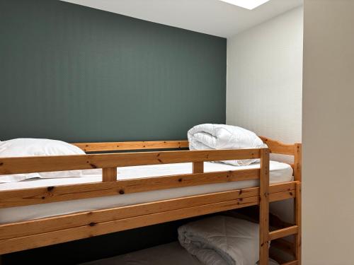 Ce lit se trouve dans un dortoir doté de 2 lits superposés et d'un mur vert. dans l'établissement Appart en front de mer pour famille : Molène, à La Bernerie-en-Retz