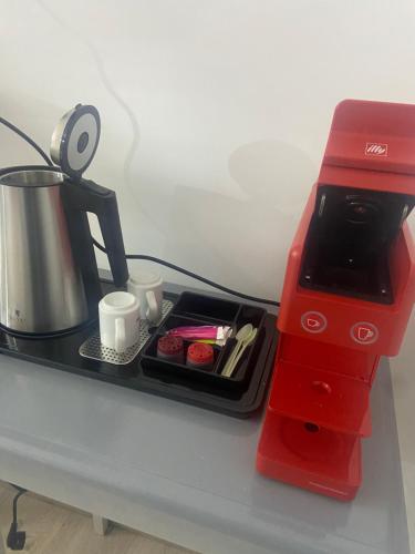 une cafetière rouge posée sur un comptoir avec un plateau dans l'établissement La Chambre du Patio, au Luc