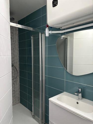 une salle de bain avec un lavabo et un miroir dans l'établissement Appart en front de mer pour famille : Molène, à La Bernerie-en-Retz