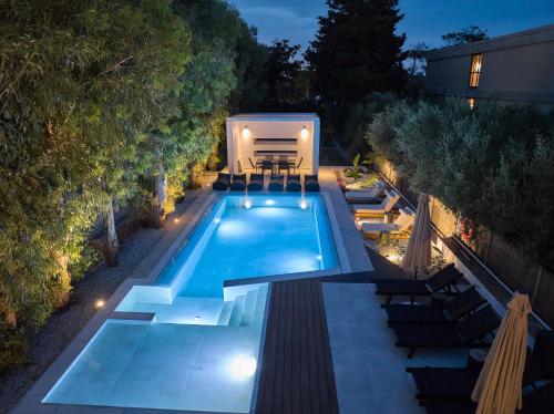 an outdoor pool with a rv in a backyard at night at MichELe Luxury apartments by Smaris Collection in Malia