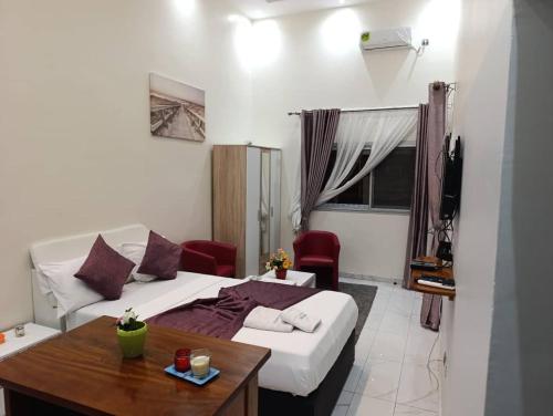 ein Schlafzimmer mit einem Bett, einem Tisch und einem Fernseher in der Unterkunft Résidence Angéline 4 studios in Yassa
