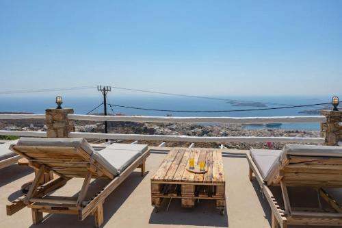 a patio with a table and chairs and the ocean at Κατοικία Uppolis με θέα τα νησιά in Ano Syros