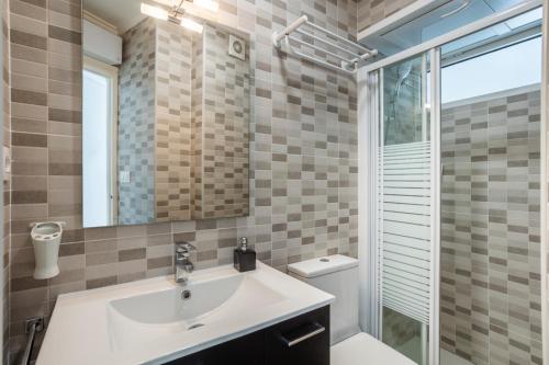 a bathroom with a sink and a toilet and a mirror at Seaside Serenity in Denia in Denia