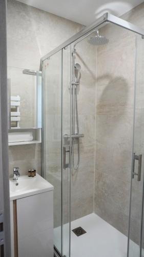 une douche avec une porte vitrée à côté d'un lavabo dans l'établissement Proche Carlton & Croisette, Appartement 202 - Palmazur Vacances, à Cannes