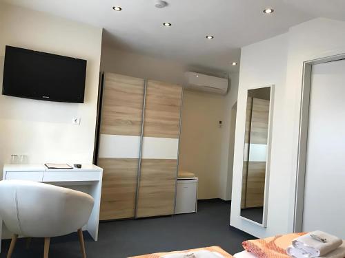 a room with a television and a desk and a chair at Gästehaus Elzblick in Rust