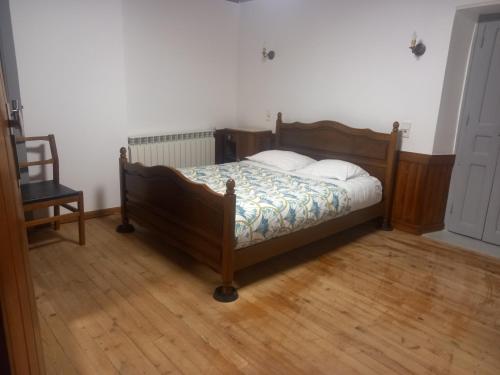 a bedroom with a wooden bed with two pillows at Appartement St Jacques in Saint-Gervais-sur-Mare