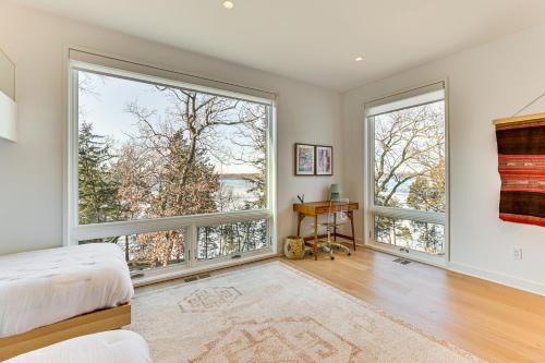 a bedroom with large windows and a bed and a desk at Green Lake Getaway with Dock Boating and Swimming! in Markesan