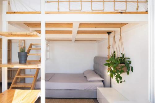 a room with a loft bed with a couch and a desk at Κατοικία Uppolis με θέα τα νησιά in Ano Syros