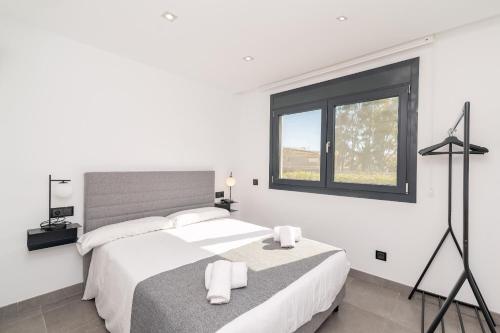 a white bedroom with two beds and a window at Beach Villa Cosins 1 Mel by Sealand Villas in Alcudia