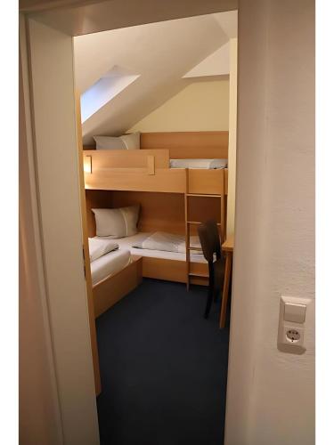 a small room with bunk beds with a desk at Gästehaus Elzblick in Rust