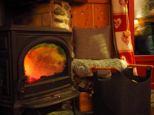 a fireplace with a chair in front of it at Les Ruisseaux in Cauterets