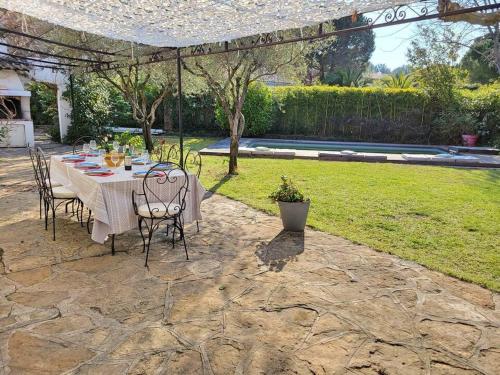 un patio avec une table et des chaises dans une cour dans l'établissement Villa climatisée avec Piscine - Terrain de Pétanque - Proche plage, à Saint-Cyr-sur-Mer