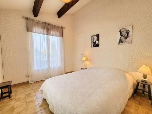 une chambre avec un grand lit blanc et une fenêtre dans l'établissement Villa climatisée avec Piscine - Terrain de Pétanque - Proche plage, à Saint-Cyr-sur-Mer