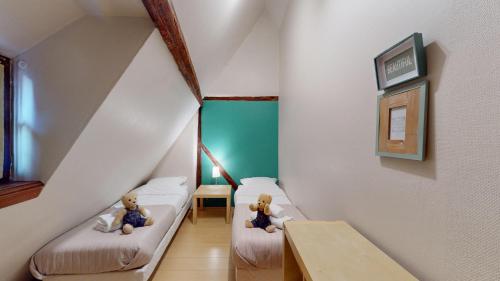 deux ours en peluche assis sur des lits dans une pièce dans l'établissement Zum Bären Duplex - 1 Parking, à Colmar