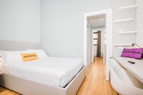 a white bedroom with a bed and a desk at Dotcampus Roma City Center in Rome