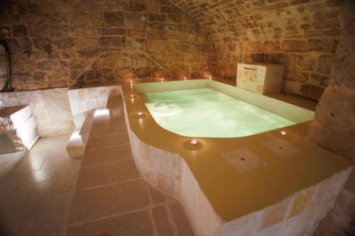 a bath tub in a room with a stone wall at Un giorno bellissimo suite & spa in Martina Franca