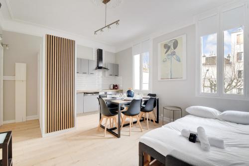 Cet appartement blanc comprend une salle à manger et une cuisine. dans l'établissement Le Jardin Anglais - 6p - Proche Gare, à Le Raincy